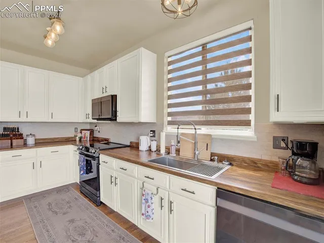 a kitchen with stainless steel appliances granite countertop a sink a stove and cabinets