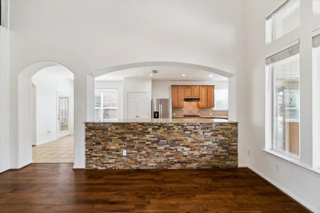 a large kitchen with stainless steel appliances kitchen island granite countertop a refrigerator and a sink