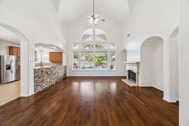 a view of empty room with fireplace and wooden floor