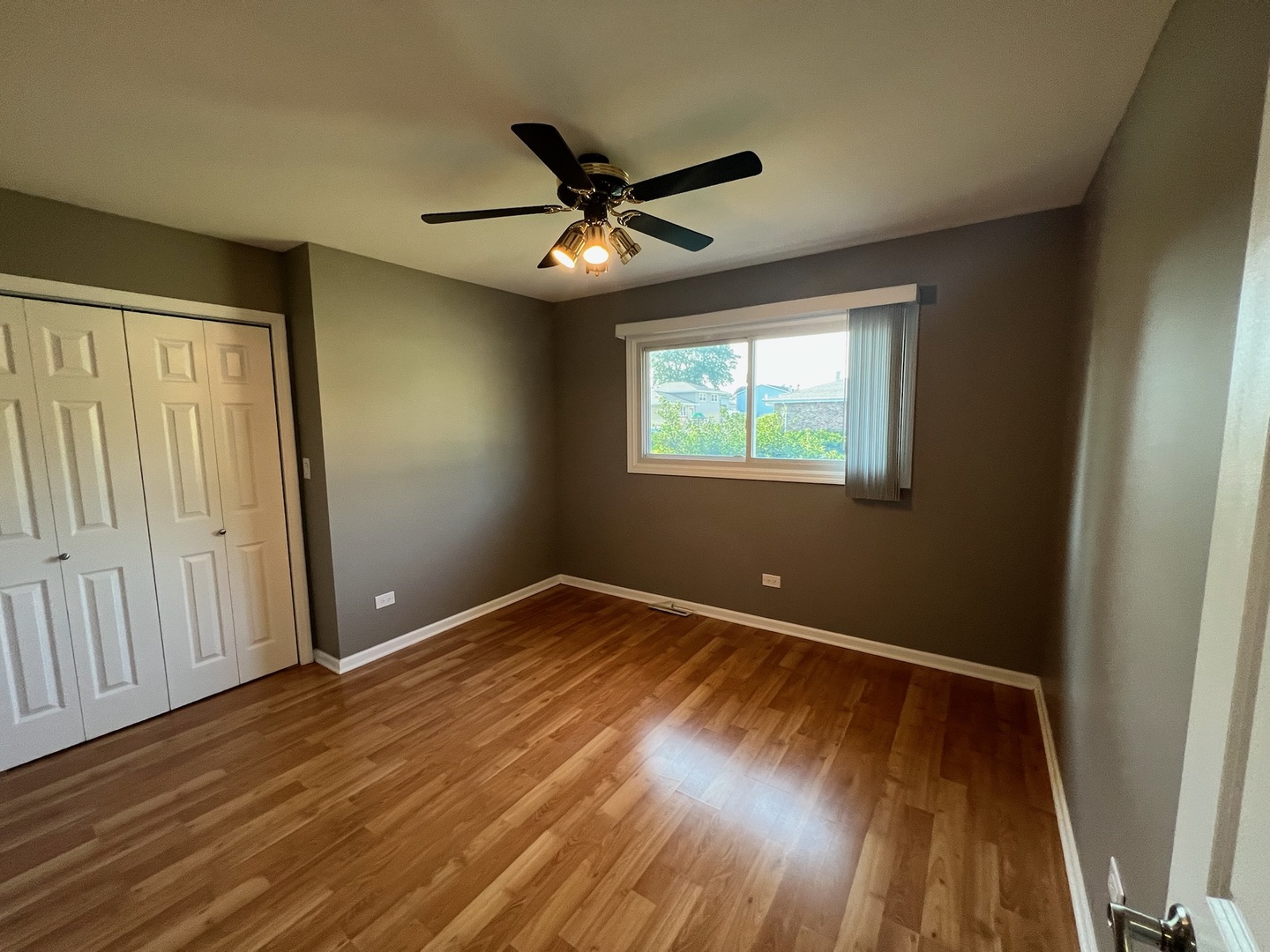 548 Delaware Trail Carol Stream, IL 60188 - Photo 18 of 26 an empty room with wooden floor fan and windows