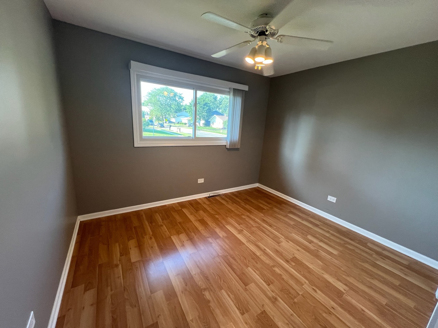 548 Delaware Trail Carol Stream, IL 60188 - Photo 20 of 26 an empty room with wooden floor chandelier fan and windows