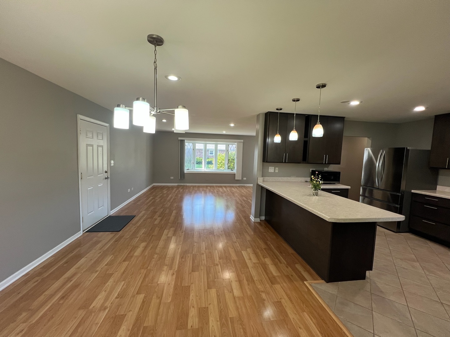 548 Delaware Trail Carol Stream, IL 60188 - Photo 5 of 26 a large room with kitchen island a sink dishwasher a refrigerator and a counter top