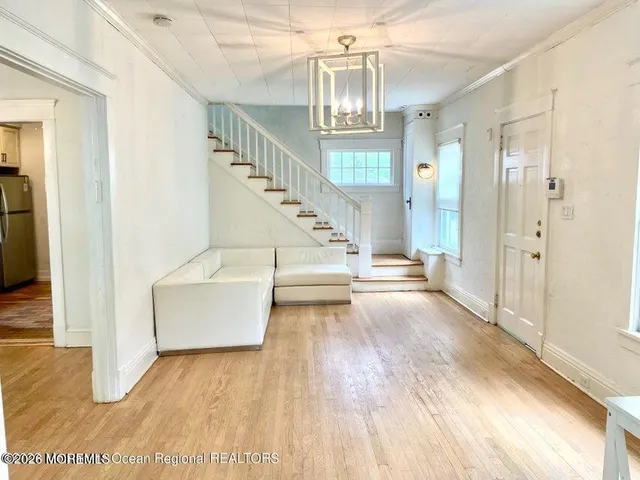a view of entryway and hall with wooden floor