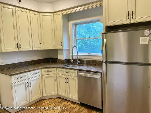 a kitchen with white cabinets and refrigerator