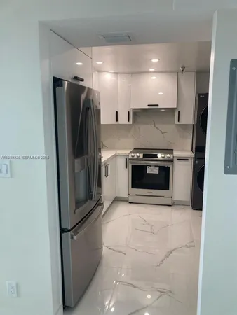 a kitchen with stainless steel appliances granite countertop a refrigerator and a stove top oven