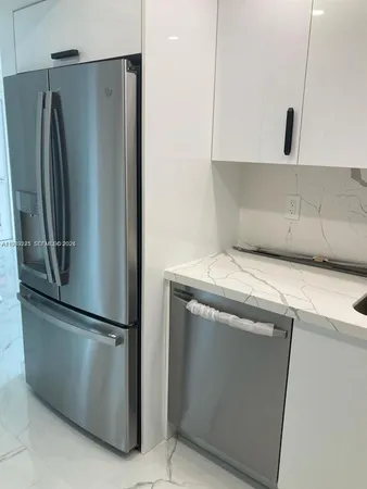 a metallic refrigerator freezer sitting in a kitchen