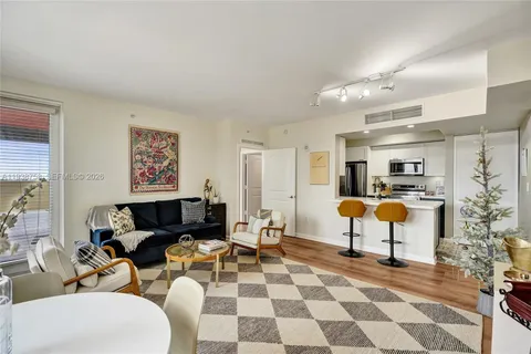 a living room with furniture and a dining table with wooden floor
