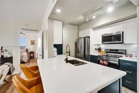 a kitchen with stainless steel appliances a stove refrigerator sink and microwave