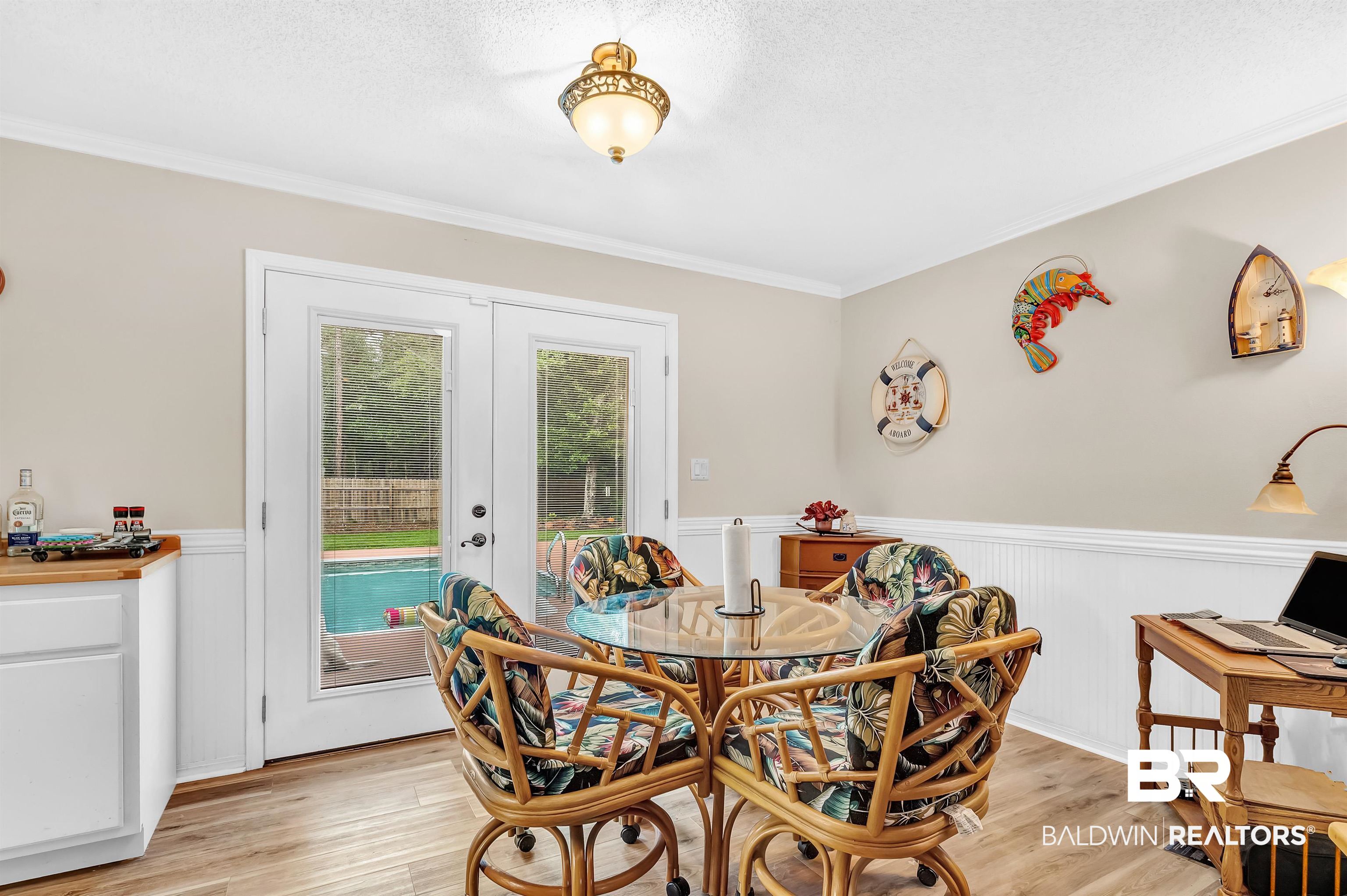 24551 Wolf Bay Drive Foley, AL 36535 - Photo 26 of 59 Dining space featuring french doors, wainscoting, light wood-style floors, and crown molding