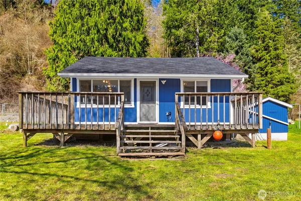 a view of a house with wooden deck and a yard
