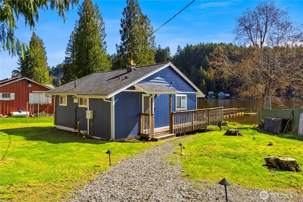 a front view of house with yard and trees in the background
