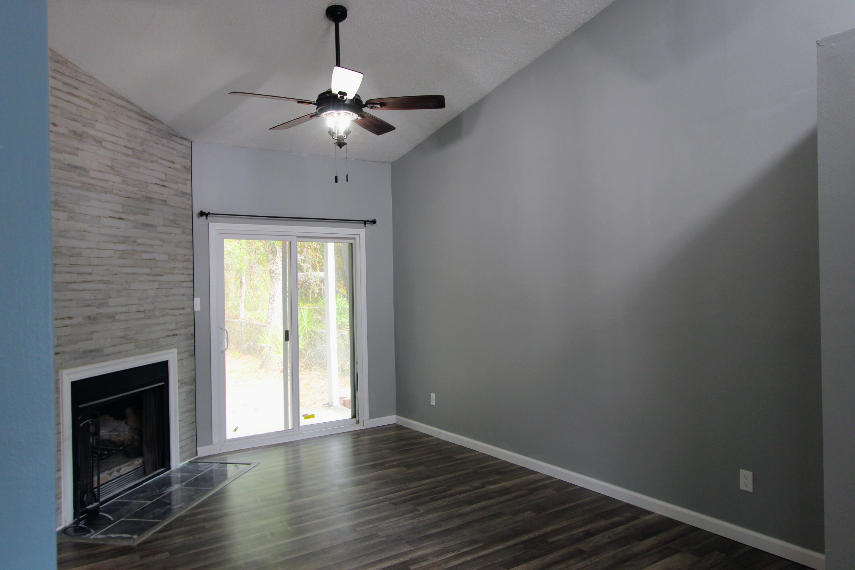 8250 Kause Road Pensacola, FL 32506 - Photo 3 of 28 a view of an empty room with wooden floor fireplace and a window