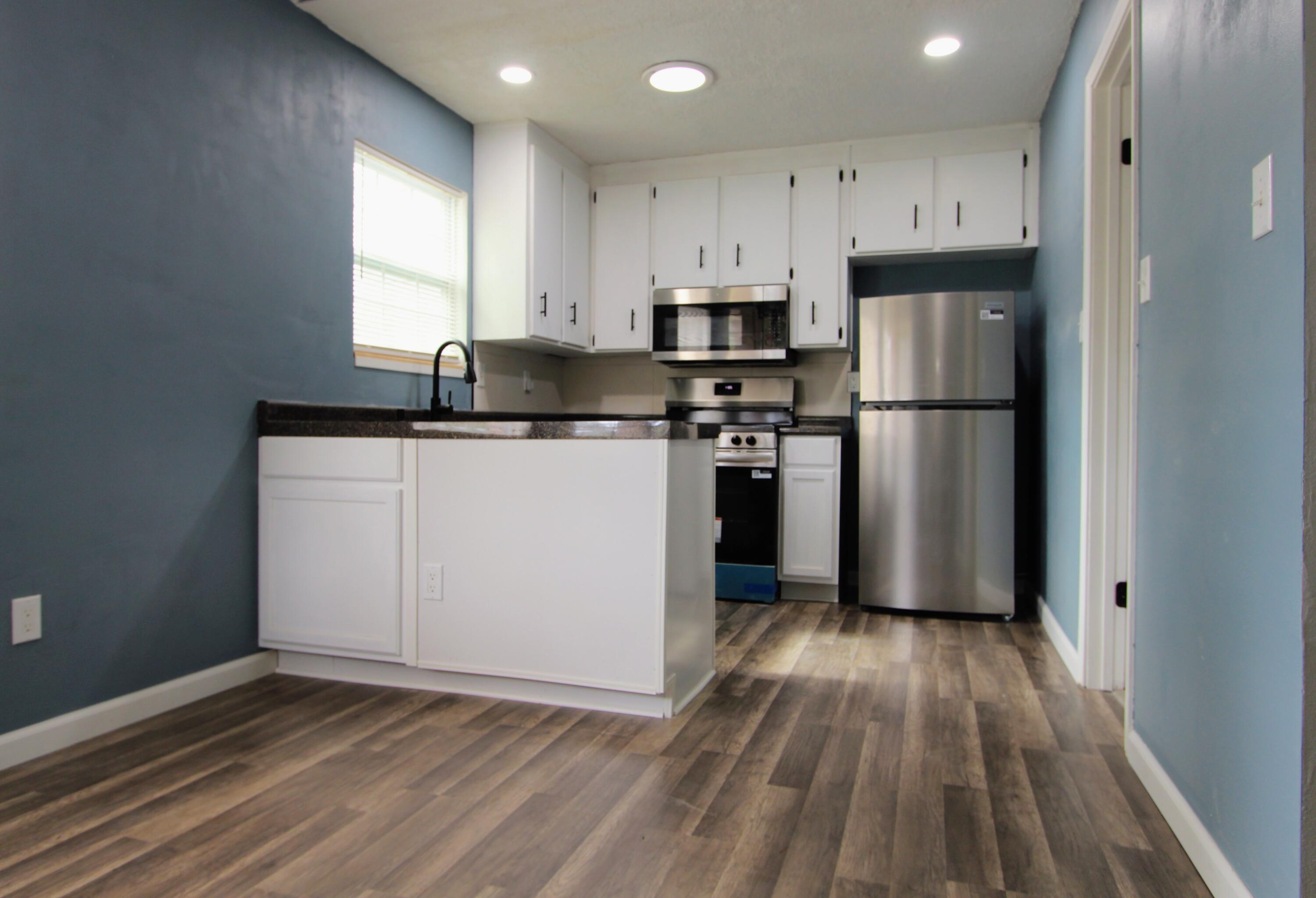 8250 Kause Road Pensacola, FL 32506 - Photo 8 of 28 a kitchen with a refrigerator a sink and wooden floor