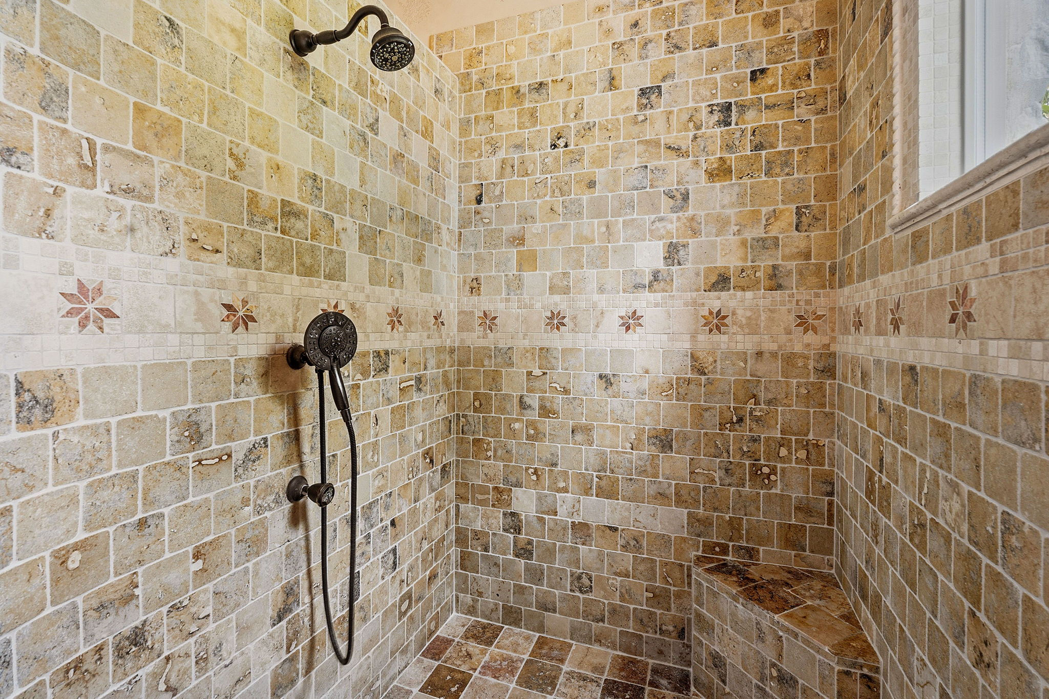 816 Brave Face Street Leander, TX 78641 - Photo 21 of 40 Ornate tilework defines this spacious walk-in shower with an integrated bench and dual shower heads.