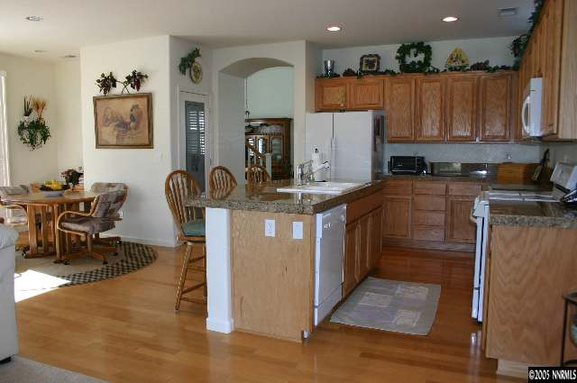 10580 Twin Bridges Way Reno, NV 89521 - Photo 4 of 9 a kitchen with kitchen island granite countertop a sink a counter top space and cabinets