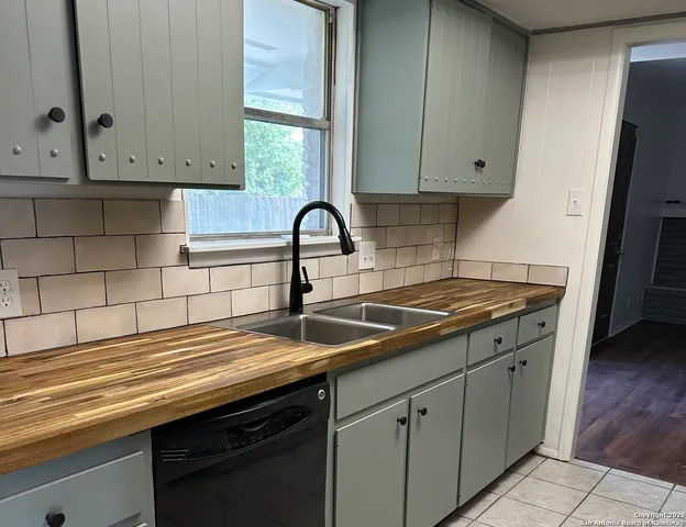 a kitchen with granite countertop a sink stove and cabinets