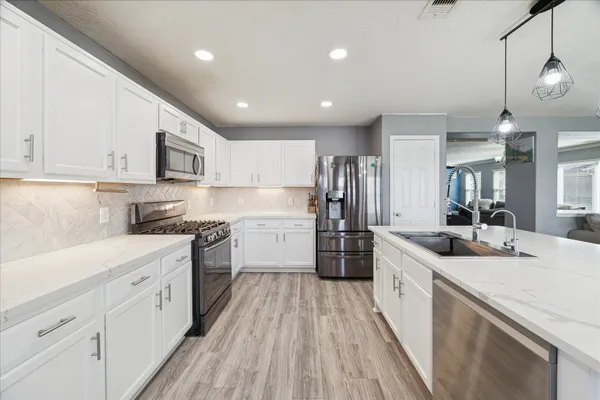a kitchen with stainless steel appliances sink stove refrigerator and cabinets