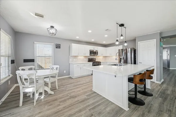 a view of kitchen with cabinets table and chairs