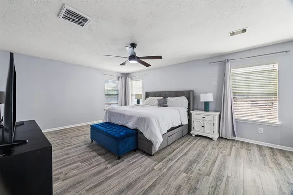 a bedroom with a bed and a flat tv screen on dresser