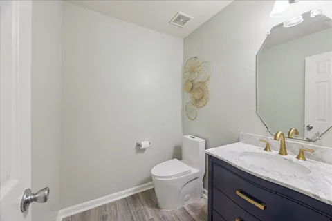 a bathroom with a granite countertop sink a toilet and a mirror