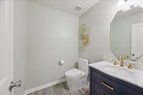 a bathroom with a granite countertop sink a toilet and a mirror