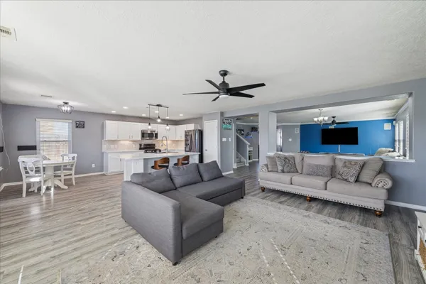 a living room with furniture and a view of kitchen