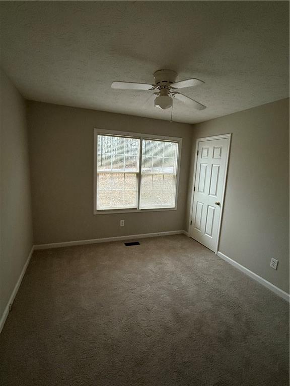 607 Senator Road Douglasville, GA 30134 - Photo 10 of 16 an empty room with windows and fan