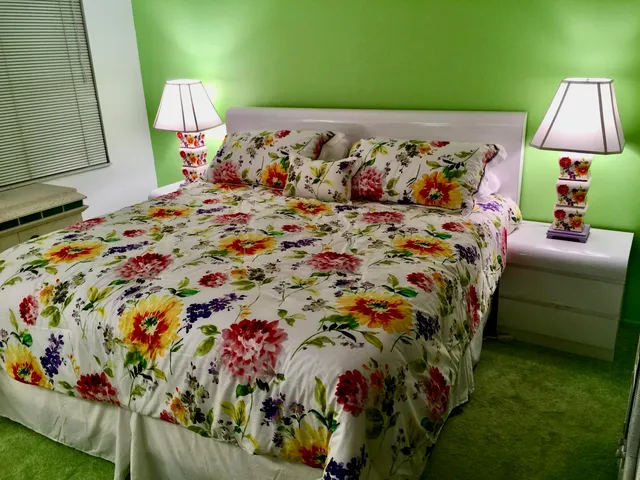 a bed sitting in a bedroom next to a lamp