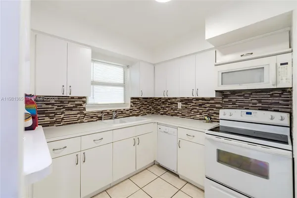 a kitchen with granite countertop a sink stove and cabinets