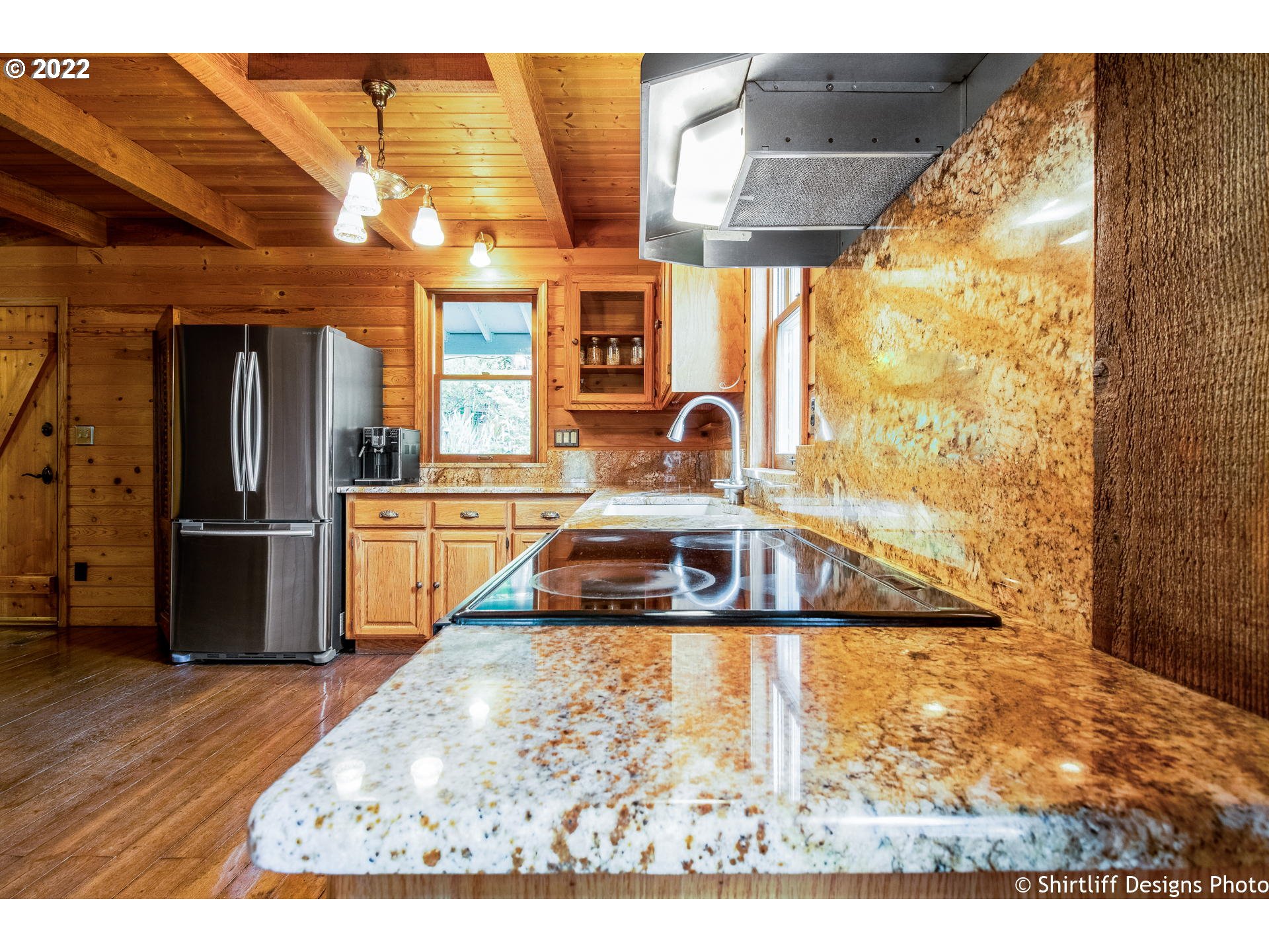31872 Fox Hollow Road Eugene, OR 97405 - Photo 13 of 32 a kitchen with stainless steel appliances kitchen island granite countertop a refrigerator and a wooden cabinets