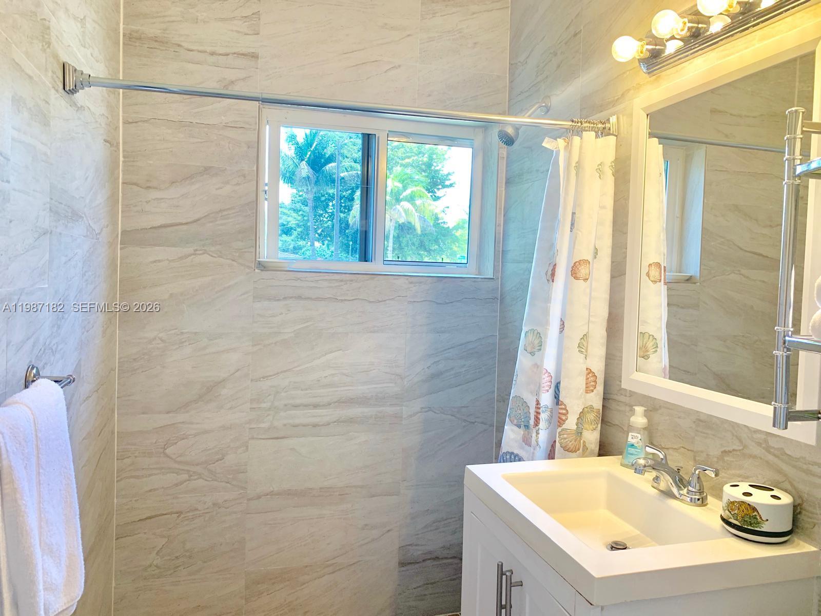 2 Northeast 45th Street Miami, FL 33137 - Photo 15 of 27 a bathroom with a sink a vanity a window and a mirror