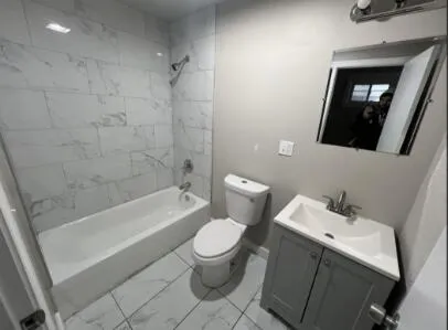 a white toilet sitting next to a bathtub