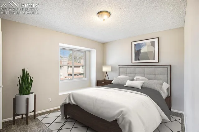 a bedroom with a bed and a painting on the wall