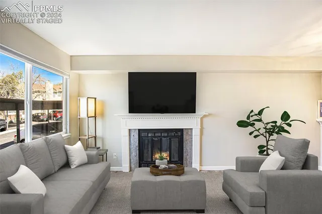 a living room with furniture a fireplace and a flat screen tv