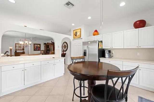 a kitchen with stainless steel appliances a table chairs and a refrigerator