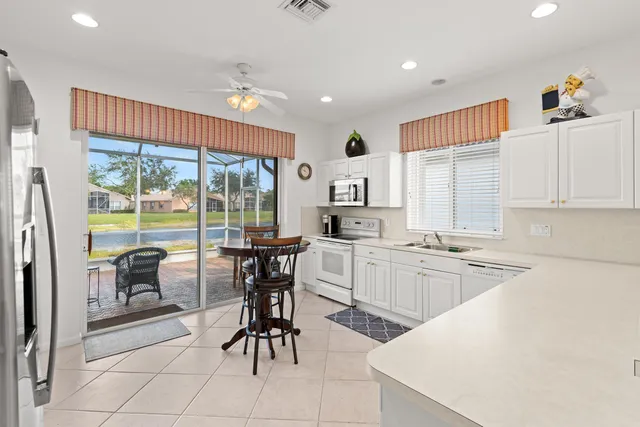 a kitchen with sink a refrigerator and chairs