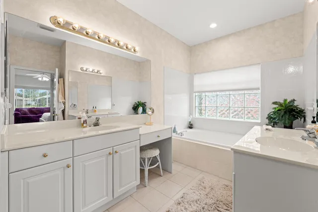 a bathroom with a tub a sink and mirror