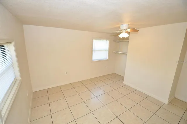 a view of an empty room with wooden floor and a floor to ceiling window