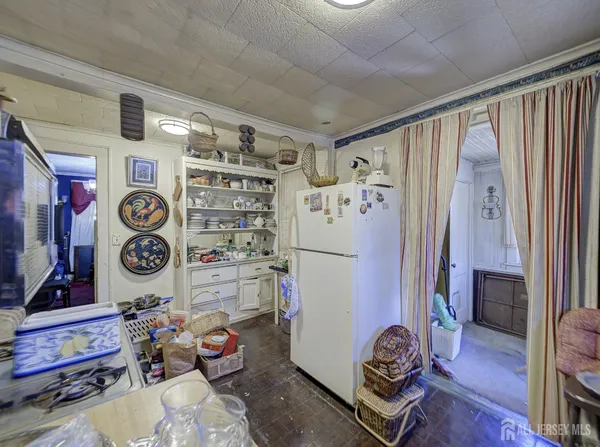 a room with lots of white furniture and wooden floor