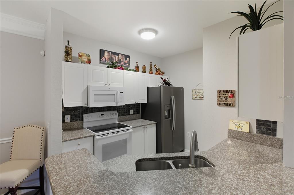 5122 Northridge Road, Unit 107 Sarasota, FL 34238 - Photo 12 of 36 a kitchen with a refrigerator and a stove