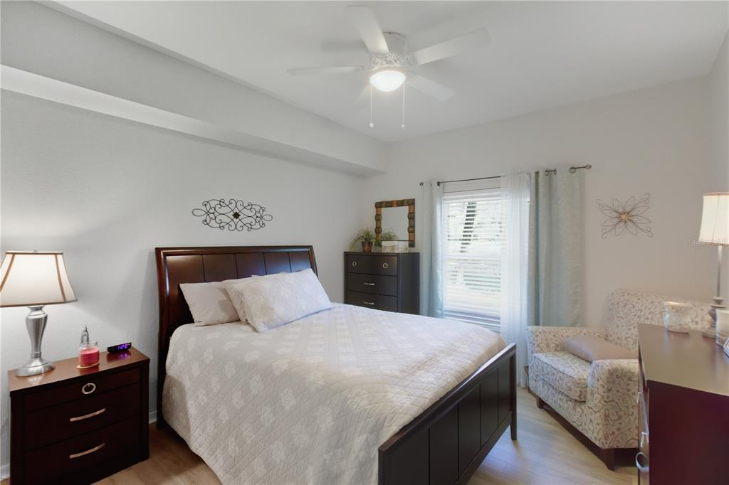 5122 Northridge Road, Unit 107 Sarasota, FL 34238 - Photo 15 of 36 a bedroom with a large bed and a chandelier