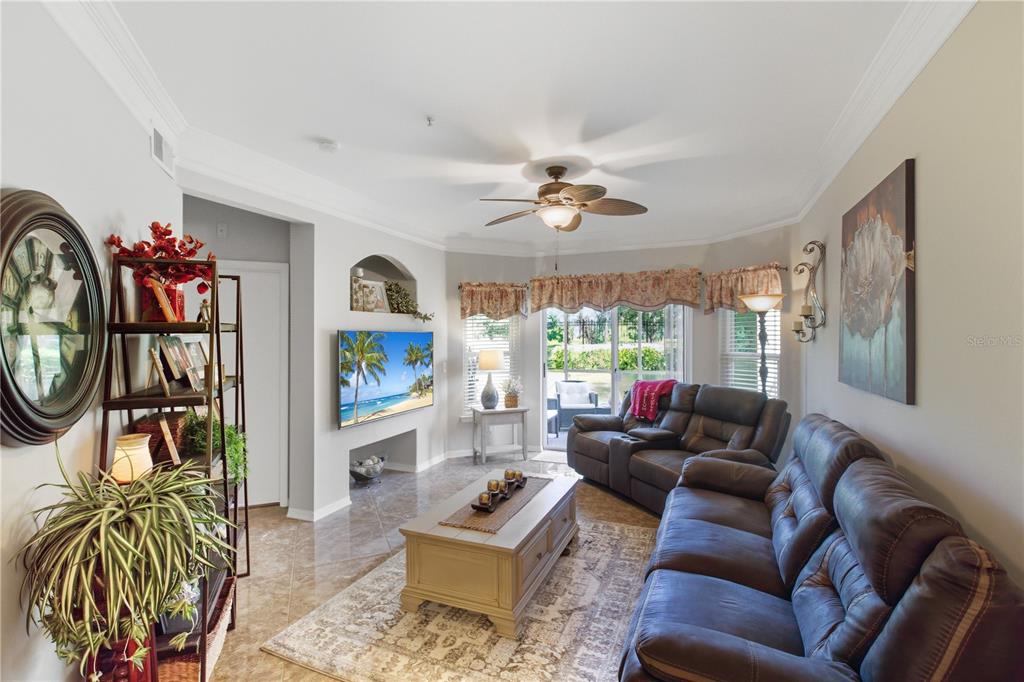 5122 Northridge Road, Unit 107 Sarasota, FL 34238 - Photo 2 of 36 a living room with furniture a fireplace and a flat screen tv