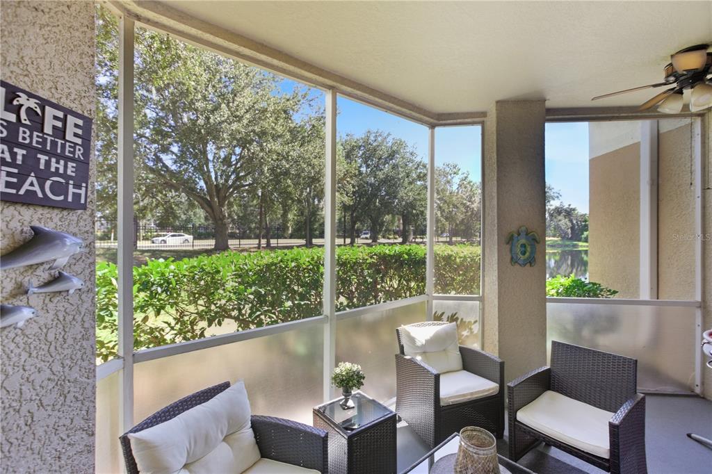 5122 Northridge Road, Unit 107 Sarasota, FL 34238 - Photo 26 of 36 a living room with large trees and a wooden floor