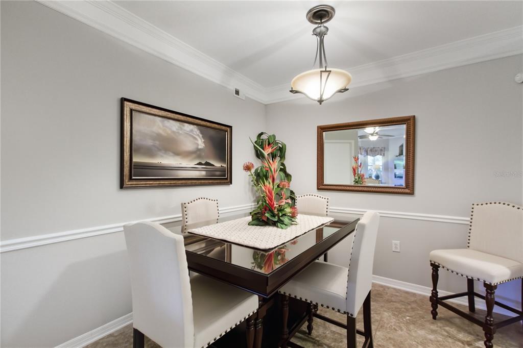 5122 Northridge Road, Unit 107 Sarasota, FL 34238 - Photo 5 of 36 a view of a dining room with furniture wooden floor and a chandelier