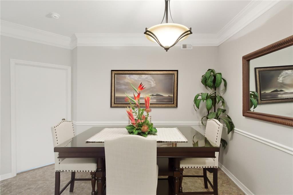5122 Northridge Road, Unit 107 Sarasota, FL 34238 - Photo 8 of 36 a view of a dining room with furniture wooden floor and a chandelier