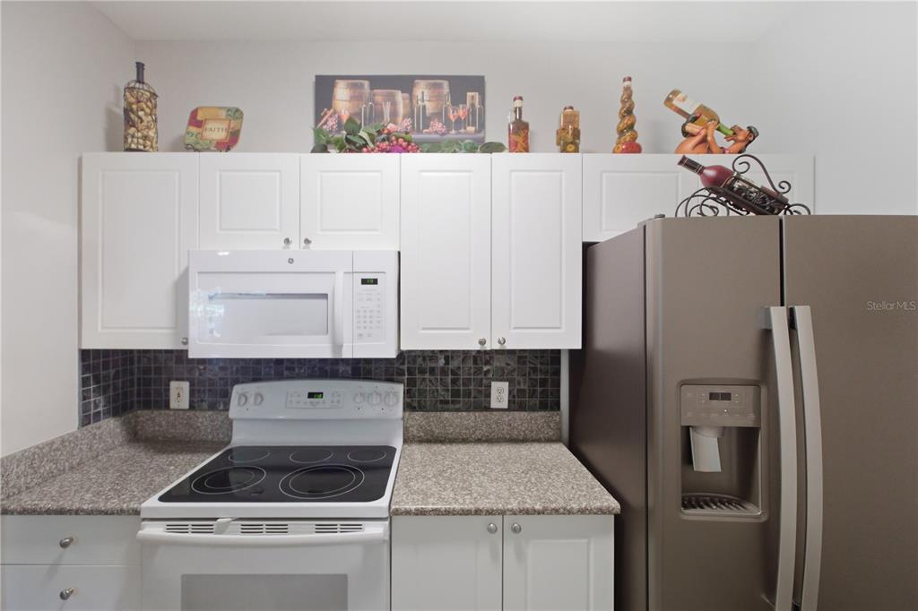 5122 Northridge Road, Unit 107 Sarasota, FL 34238 - Photo 10 of 36 a kitchen with a refrigerator and cabinets