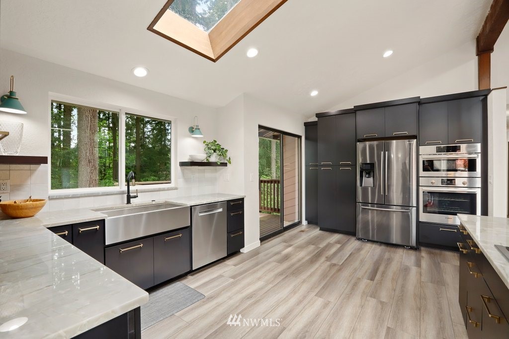 20830 28th Avenue Southeast Bothell, WA 98021 - Photo 12 of 40 a kitchen with stainless steel appliances granite countertop a refrigerator and a sink
