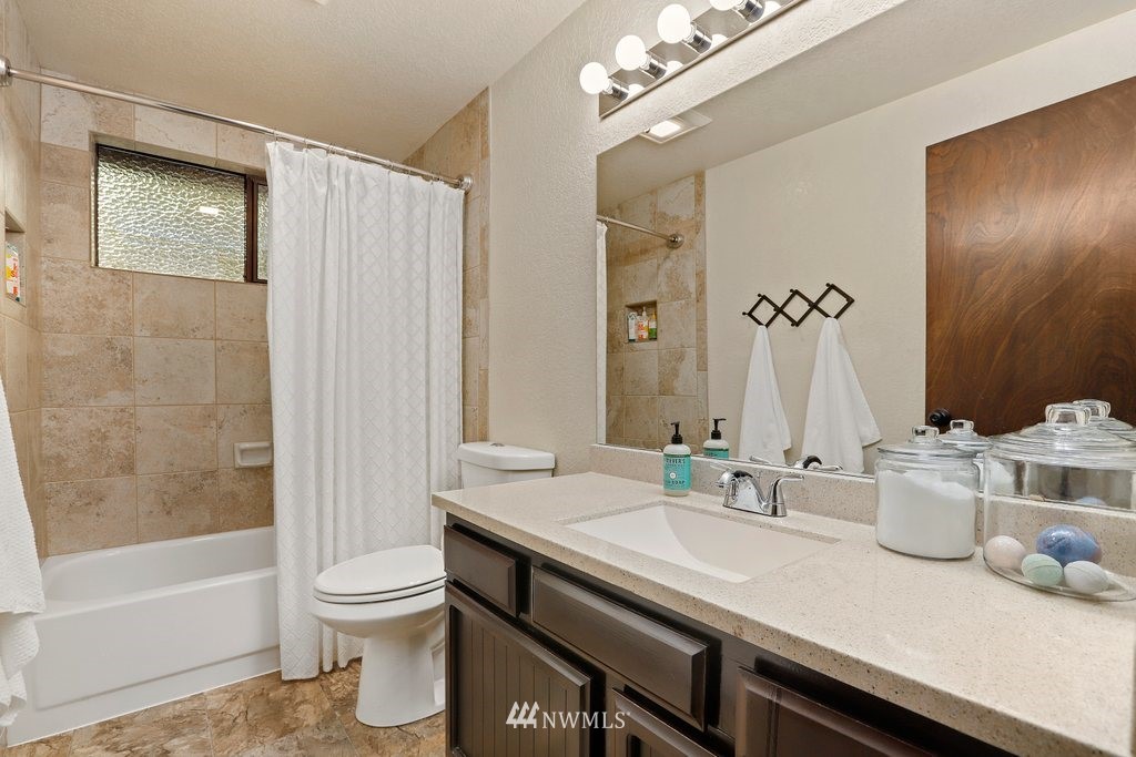 20830 28th Avenue Southeast Bothell, WA 98021 - Photo 24 of 40 a bathroom with a granite countertop sink a toilet a mirror and shower