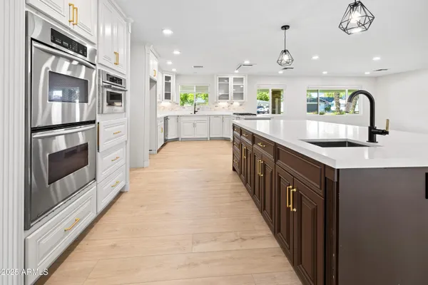 a kitchen with granite countertop a sink stainless steel appliances and window