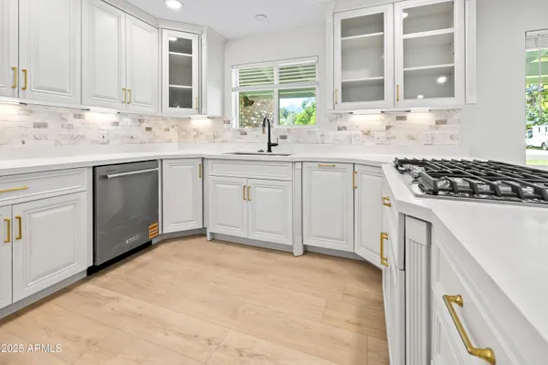 a kitchen with granite countertop white cabinets and window